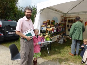 Bruno Van de Casteele, conseiller CPAS, avec sa fille devant le stand de Natagora. Quel beaux nichoirs!